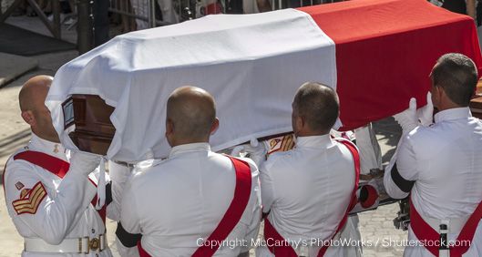 men in uniform carrying a coffin