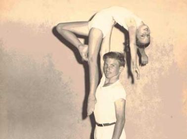 Young Sara Ashworth balancing on a gym partners extended arm