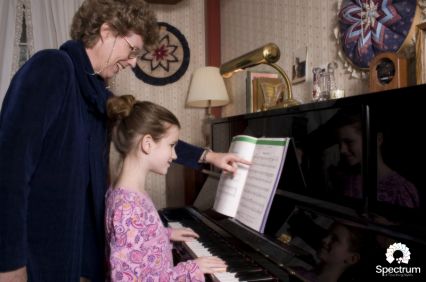 grandmother teaching grandchild to play piano