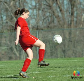 girl kicking a soccer ball