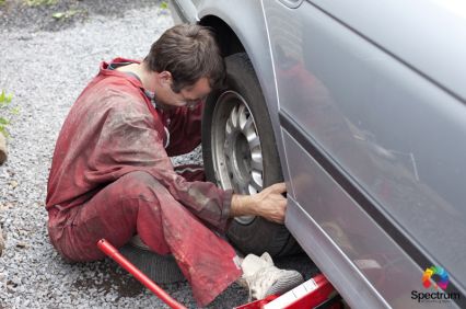 car technician replacing a car tire